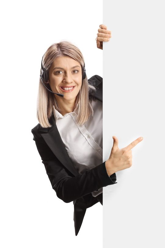 mujer con microfofono sonriente apareciendo tras una puerta